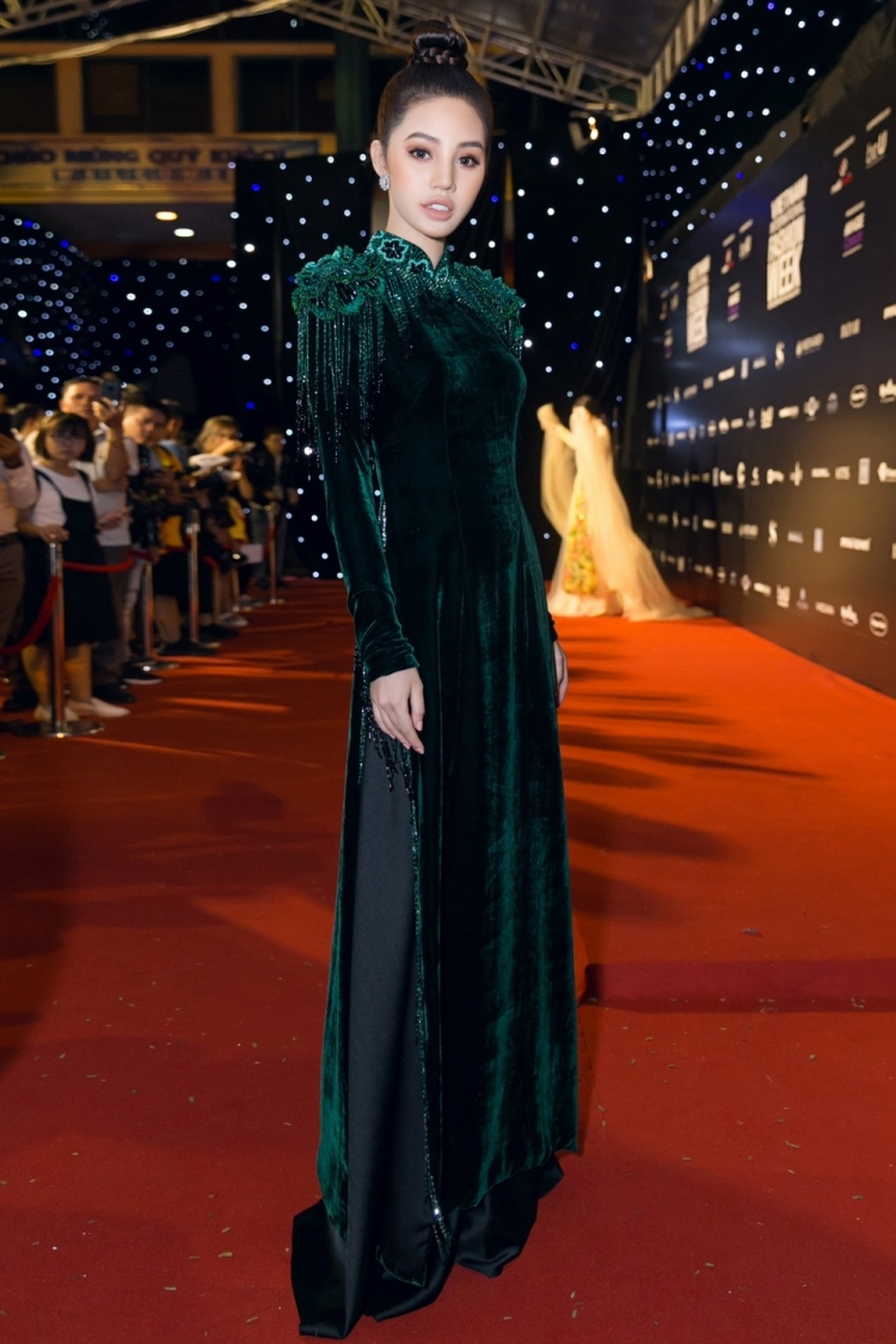 Hoàng Thuỳ đẹp nhất tuần; Thái Trinh diện trang phục lộ vòng 1 "xập xệ" lọt top sao xấu - 4 Jolie Nguyễn đẹp mặn mà với áo dài nhung màu xanh cổ vịt. Người đẹp bới tóc gọn gàng, sang trọng đúng chất Sài Gòn xưa. Các chi tiết như cầu vai tua rua đính đá, cổ thêu hoa giúp trang phục trở nên tân thời chứ không bị sến.