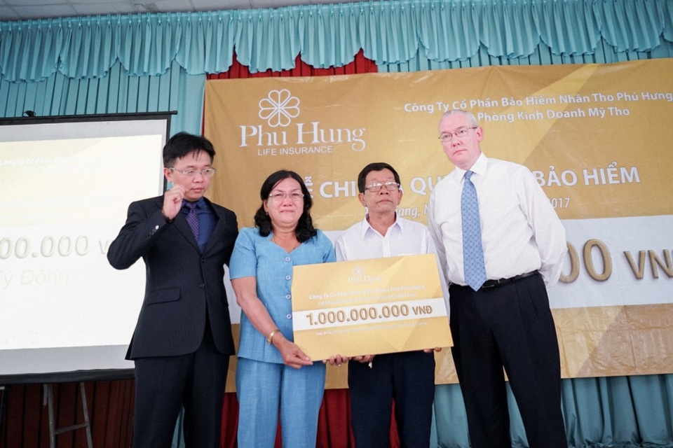 Phú Hưng Life chi trả nhanh quyền lợi cho khách hàng 1 tỷ đồng - 3 Trao bảng chi trả cho gia đình anh Lê Vĩnh Phú trong sự xúc động của gia đình.