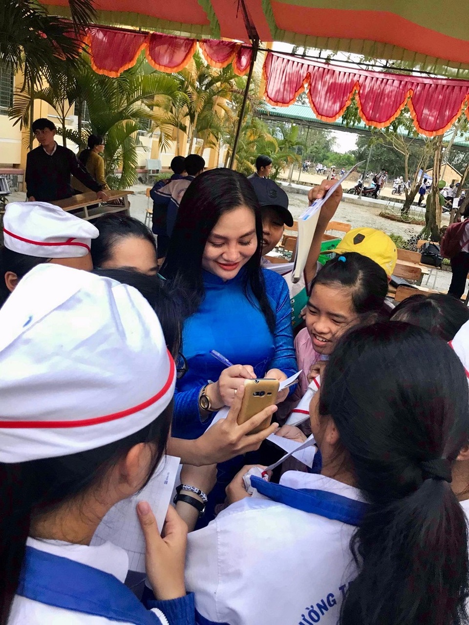 Hoa hậu vì cộng đồng Trần Huyền Nhung liên tục tham gia hoạt động vì cộng đồng. - 8 Các em học sinh vây quanh xin chữ ký của Hoa Hậu