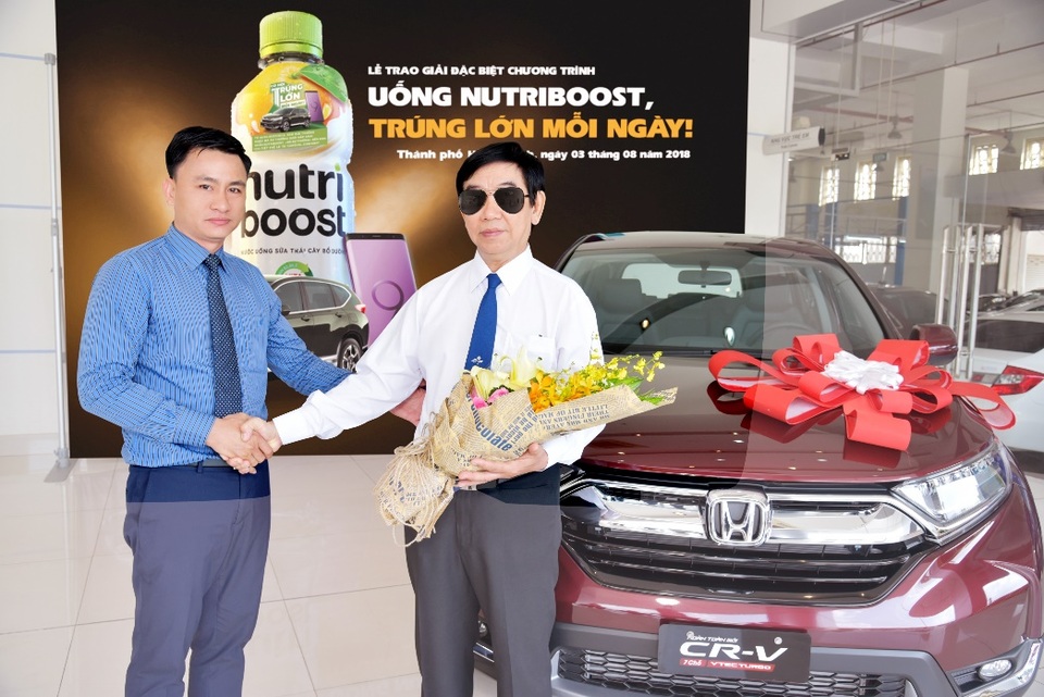 Uống sữa trái cây, trúng luôn giải Đặc biệt trị giá hơn 1 tỷ đồng - 2 Đại diện đại lý Honda Phước Thành (bên trái) chúc mừng vị khách may mắn của chương trình Uống Nutriboost, trúng lớn mỗi ngày