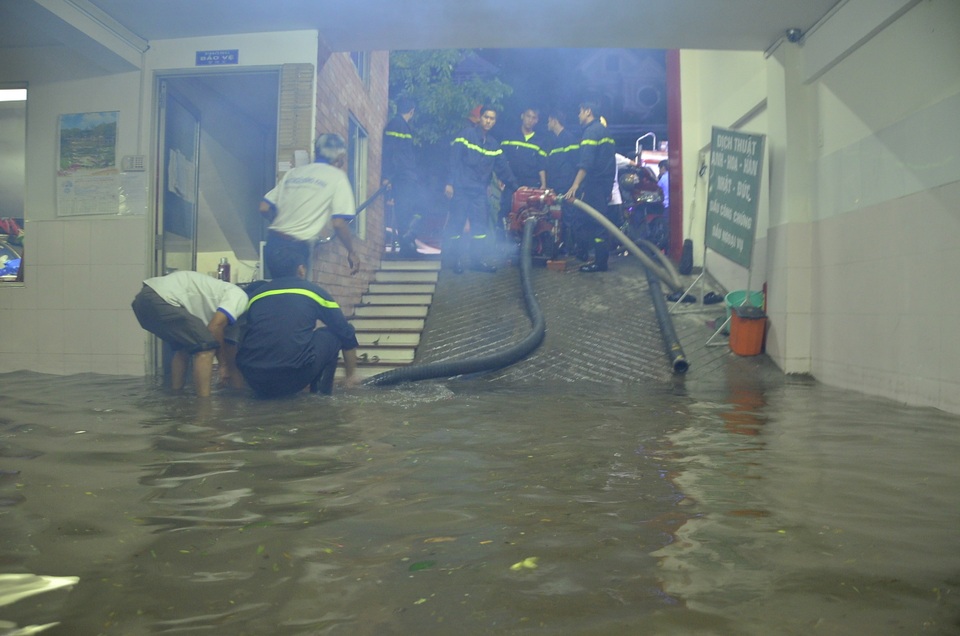 Lực lượng cứu hộ tiến hành bơm nước ra khỏi hầm tòa nhà