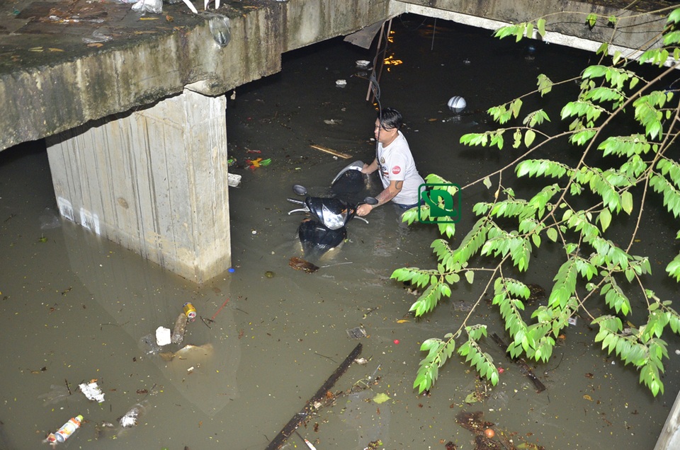 Nhân viên bãi xe cố đẩy xe của khách ra ngoài sau khi bị ngập
