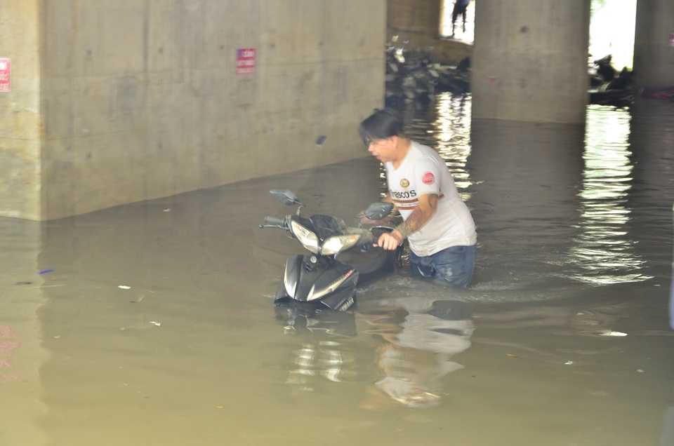 
Nhân viên bãi xe dầm mình dưới nước bẩn, tìm và dắt xe ra cho khách
