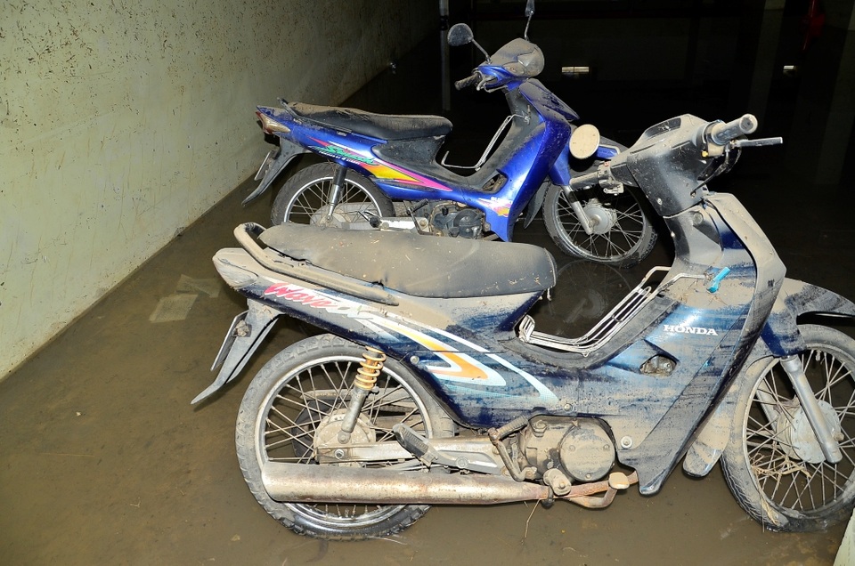 Những chiếc xe của sinh viên dính đầy bùn sau khi bị ngâm nước trong hầm