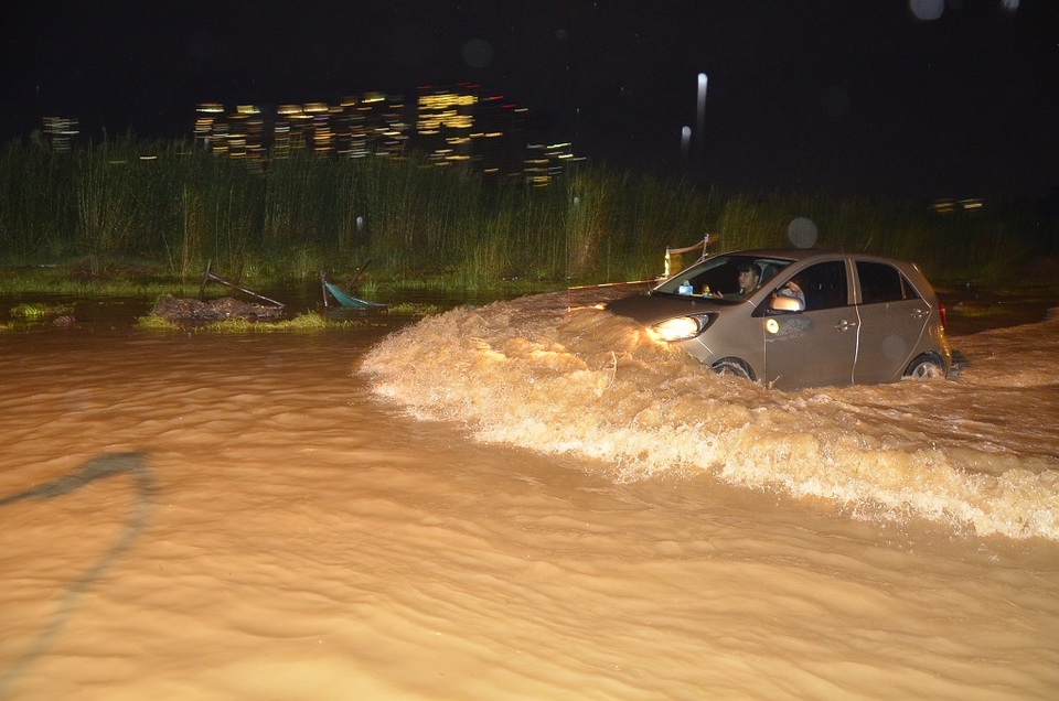Một chiếc ô tô chạy nhanh tạo sóng trên đường