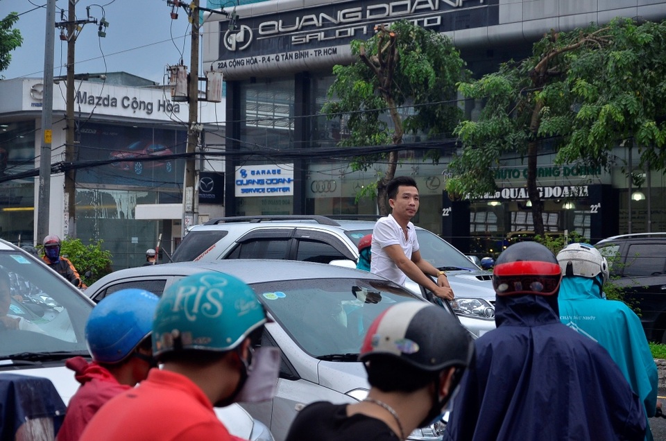 Một tài xế mở cửa đứng ngóng tình trạng kẹt xe phía trước