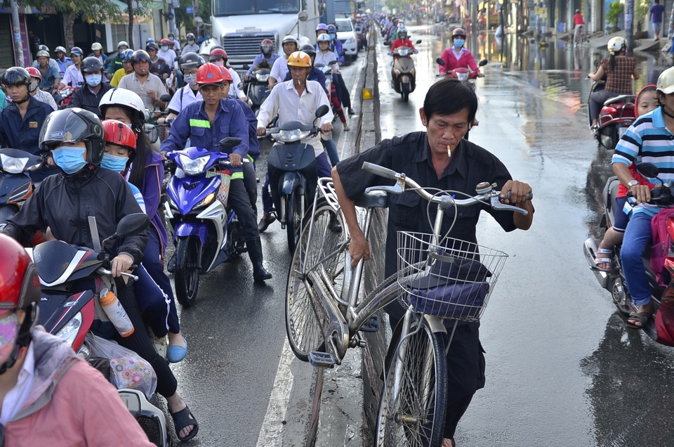 Người đàn ông vác xe đạp qua dải phân cách để thoát khỏi kẹt xe
