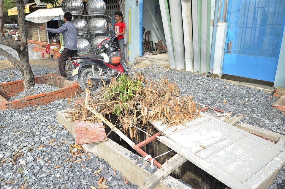 Một hố sâu trước cửa nhà dân được che đậy tạm bợ