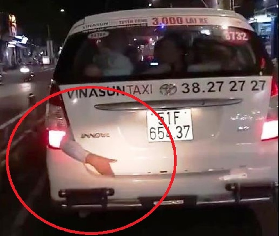 Cánh tay người bị kẹt sau xe taxi khiến người dân xôn xao (ảnh cắt từ clip)
