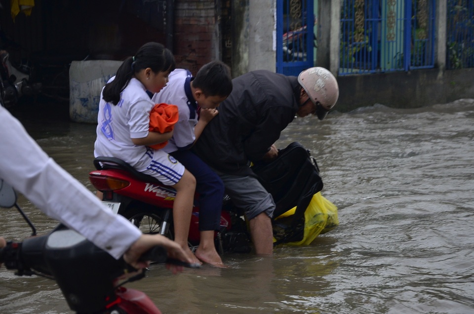 Người đàn ông làm rơi cặp sách của con xuống nước