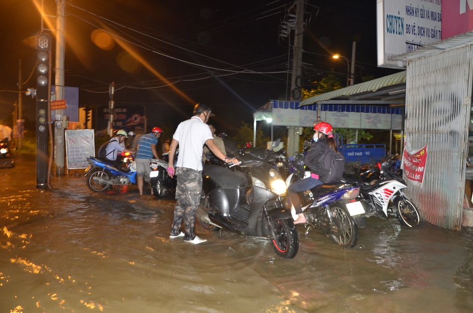 Rất đông người dân dừng xe 2 bên đường chờ nước rút mới về nhà