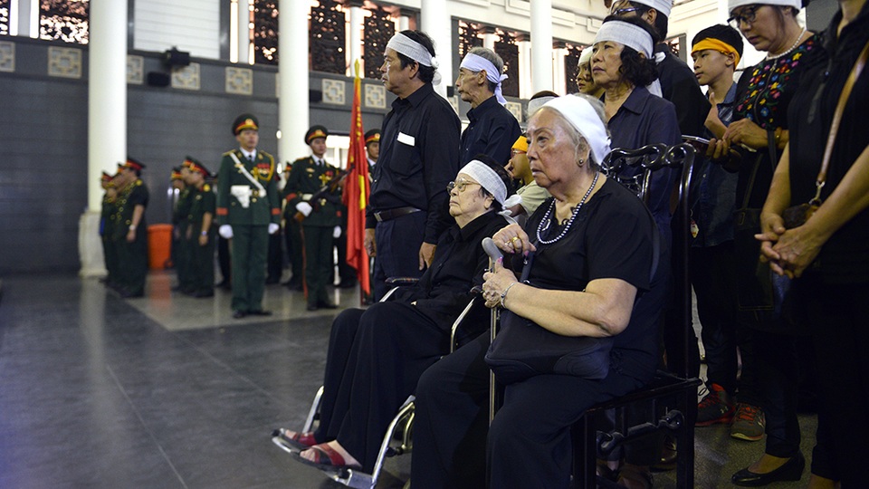 Phu nhân nhạc sĩ Nguyễn Đức Toàn phải ngồi xe lăn trong lễ tang chồng.