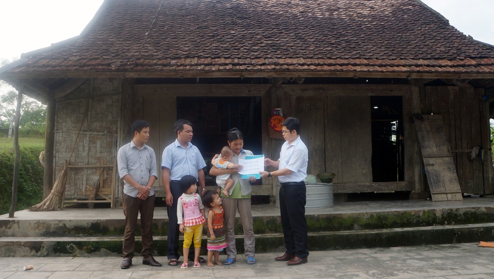 Thay mặt PV Dân trí, ông Trình Văn Nhã - Phó chủ tịch UBND huyện Thanh Chương trao quà đến chị Bảy.