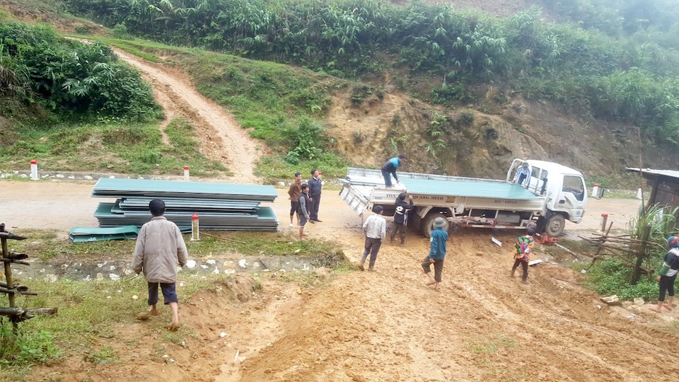 Gùi tôn, xà thép vượt dốc, leo đồi xây điểm trường Pà Khốm - 1 Chiếc xe chở vật liệu chỉ đỗ ở ngoài đường lớn để bốc xuống.