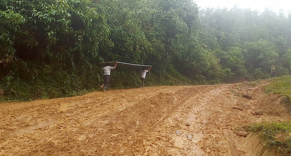 Gùi tôn, xà thép vượt dốc, leo đồi xây điểm trường Pà Khốm - 7 Mưa đất bùn nhão nhoẹt đi lại vất vả gấp bội khi mang vác thêm những vật liệu xây dựng.