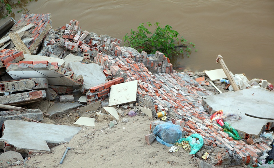 
Tường gạch, vôi vữa ngổn ngang bên mép nước sông Hồng.
