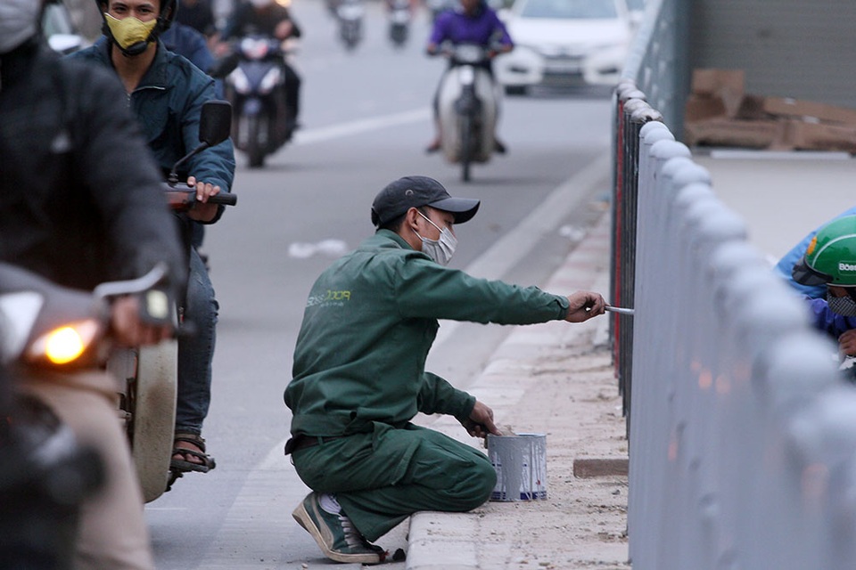 
Tại nhà chờ khu vực Lê Văn Lương kéo dài, công nhân đang sơn lại hàng rào.
