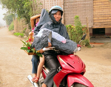 Ông bố chở hai con đi tìm nhà cô giáo chúc mừng ngay trong sáng 20/11. (Ảnh: Nguyễn Duy)