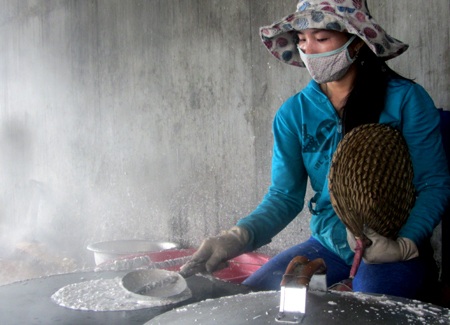 Nghề làm bánh tráng nước cốt dừa Hoài Nhơn - 3 Trong làng khói trắng, người phụ nữ tần mẫn tạo hình cho chiếc bánh.