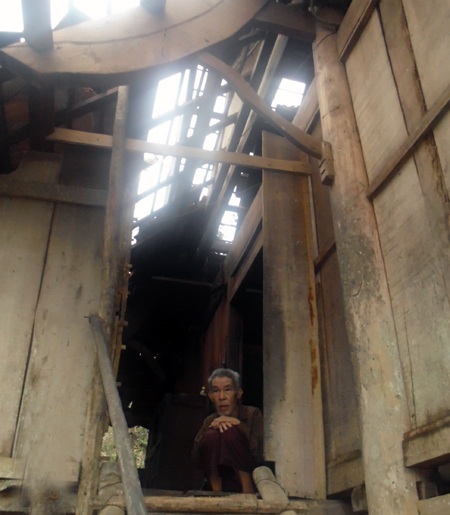 Một cụ già ngồi co ro trong ngồi nhà bị lốc xé nát ngói lợp.