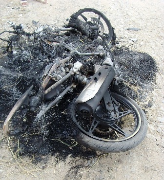 Chiếc xe máy của hai đối tượng trộm chó bị người dân đốt cháy rụi.