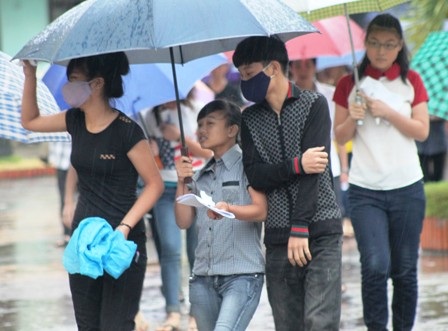 Thí sinh ra về trong cơn mưa. (Ảnh: Doãn Hòa)