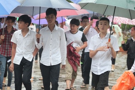 Thí sinh ra về trong cơn mưa. (Ảnh: Doãn Hòa)