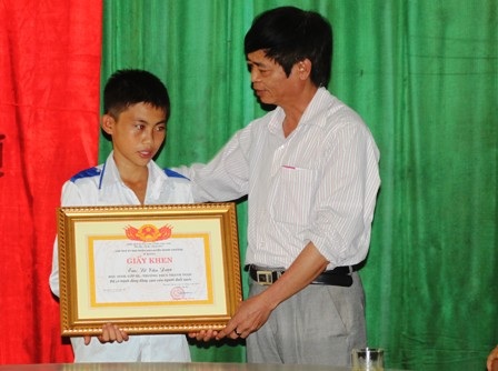 Ông Đặng Anh Dũng - Phó Bí thư thường trực Huyện ủy thanh Chương trao giấy khen cho em Lê Văn Được