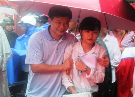 Hai bố con che chung ô.