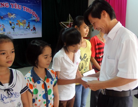 Ông Dương Ngọc Hùng - GĐ BQLKBTTN Pù Huống trao quà cho các em khuyết tật. 