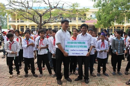 Đại diện ngân hàng Phương Đông trao quà cho các em học sinh trường THCS Quỳnh Trang