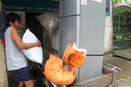 Anh Bùi Văn Hùng (32 tuổi, xóm 5, xã Hưng Nhân, huyện Hưng Nguyên) đưa đồ lên gác tránh lũ
