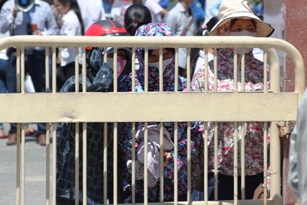 Phụ huynh kiên nhẫn đứng dưới nắng nóng để đón con