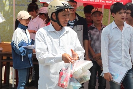 Phụ huynh mang cơm, nước đợi con trong bóng râm