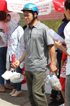 Một ông bố đợi con rời phòng thi trong nắng nóng