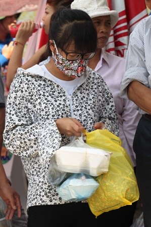 Một phụ huynh xách cơm, nước tìm con trông đám đông 