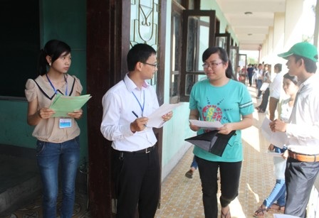 Các tình nguyện viên hướng dẫn các thí sinh đến phòng thi. (Ảnh: Nguyễn Duy).