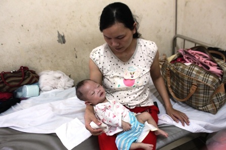 Chị Lê Thị Uyên đau đớn khi bệnh tình con mình ngày một nặng hơn.