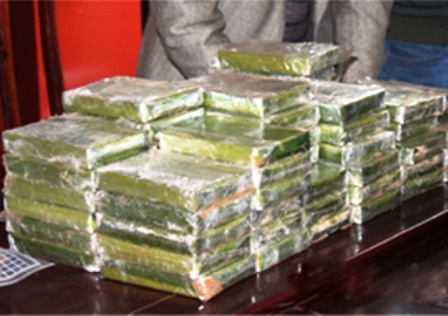 Đối tượng Hồ Sự Cơ cùng tang vật 60 bánh heroin tại cơ quan công an (Ảnh: Minh Tâm)