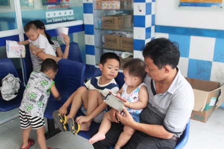 Phụ huynh đưa con đến điểm tiêm phòng vắc-xin sởi