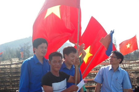 Anh Nguyễn Đình Hùng - Bí thư tỉnh Đoàn Nghệ An trao cờ và quà cho ngư dân