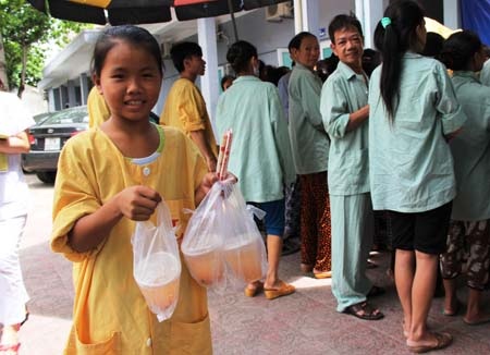 Em Đinh Thị Kim Khánh (12 tuổi, xã Xuân Hòa, Nam Đàn) nhận cơm miễn phí cho hai bố con