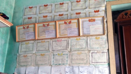 Trên bức tường ken kín những Bằng khen, giấy khen của Thành.