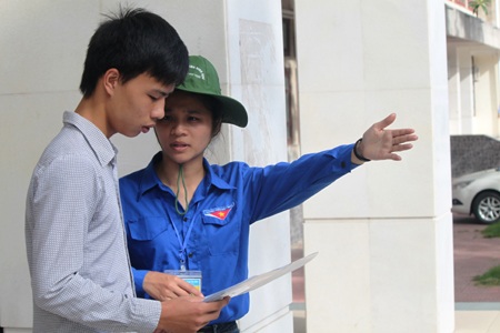 Tình nguyện viên hướng dẫn các thí sinh đến khu vực thi trong trường ĐH Vinh. (Ảnh: Doãn Hòa)