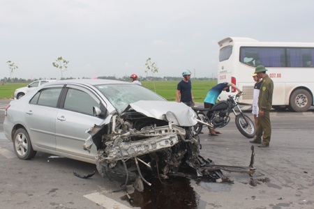 Chiếc xe 4 chỗ ngồi nát bét phần đầu, nhiều vệt dầu loang lổ trên mặt đường 