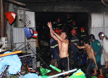 Các tiểu thương có kho hàng bên cạnh vụ cháy hô hào mọi người vận chuyển hàng hóa ra bên ngoài