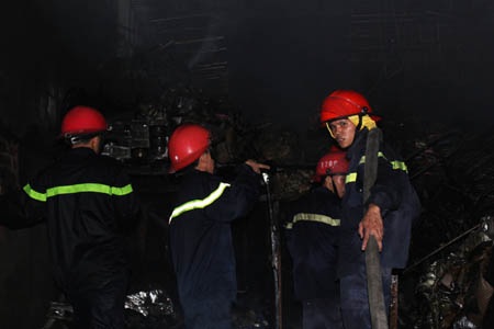 Các tiểu thương có kho hàng bên cạnh vụ cháy hô hào mọi người vận chuyển hàng hóa ra bên ngoài