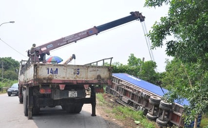 Bị xe con “cắt mặt”,  container chở hàng chục tấn hàng lộn nhào - 1