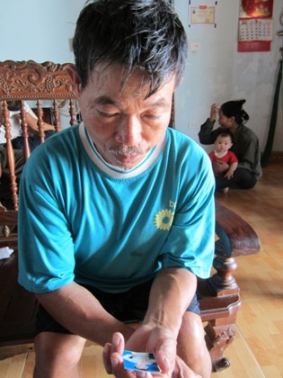 Ông Nguyễn Văn Đạt, ông nội cháu Tuấn, ngày ngày cầm tấm ảnh cháu nội rơm rớm nước mắt.