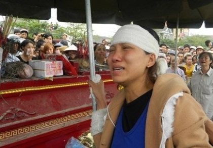 Người vợ trẻ vật vã đau đớn bên thi thể chồng.